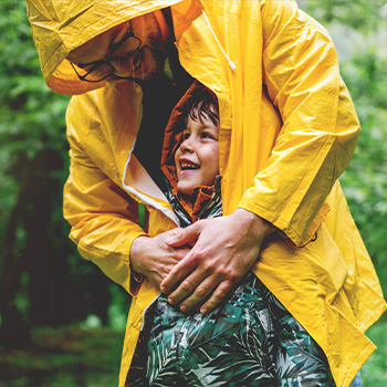 Adulto copre bambino con impermeabile