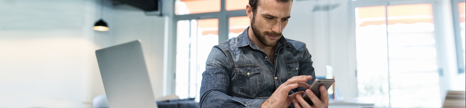 Un giovane uomo interagisce con uno smartphone