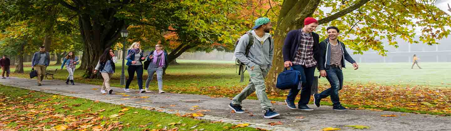 Ragazze e ragazzi sorridenti camminano in un parco