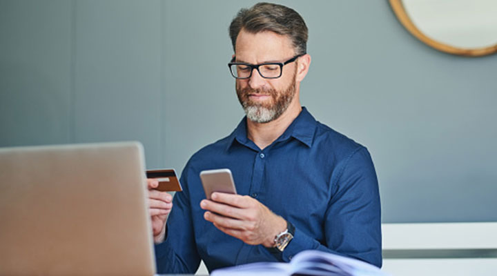 Un uomo acquista online con lo smartphone e partecipa al programma di formazione di WellMAKERS Academy by BNL BNP Paribas. 